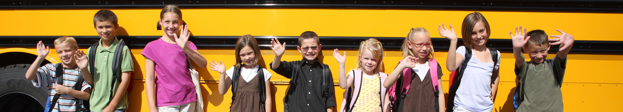 students standing in front of school bus