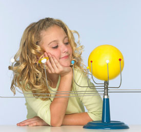 student looking at a a model of the solar system