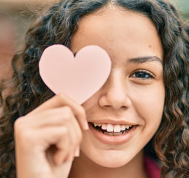 student holding a heart shaped piece of paper